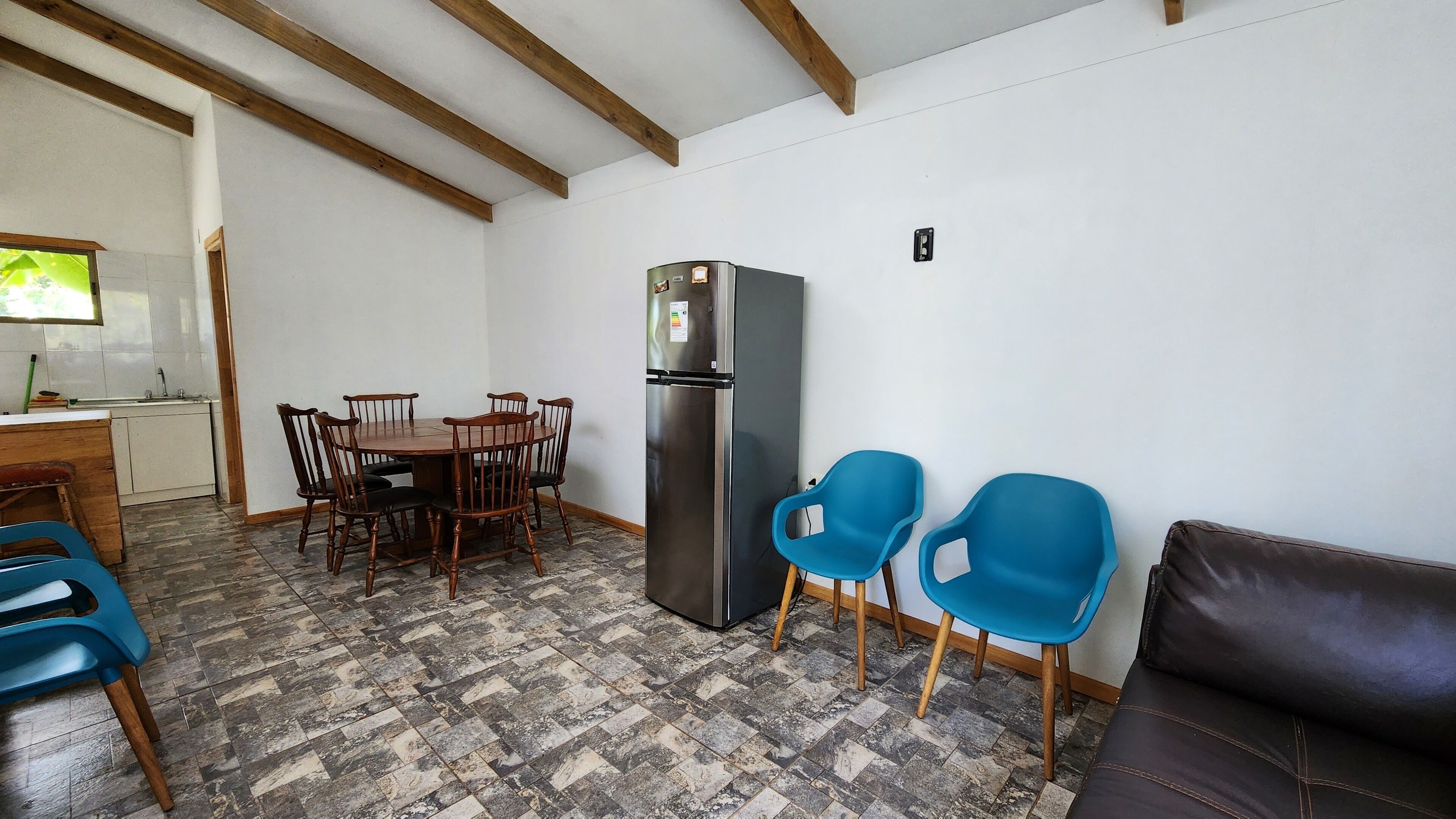 A compact living space with a dining area, a refrigerator, and a couch.