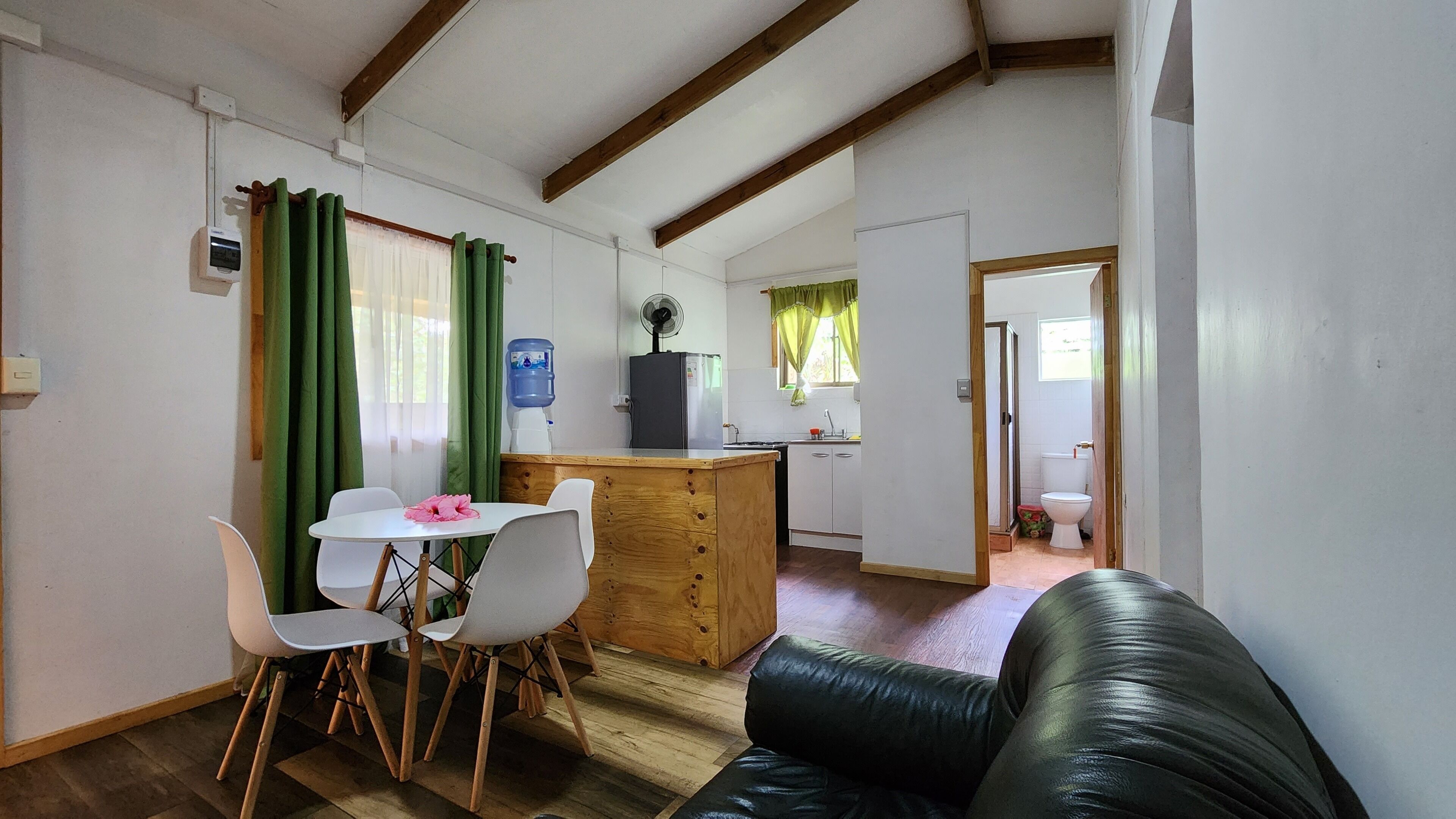 Un espacio habitable compacto con comedor, kitchenette y baño separado.