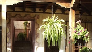 A garden with a variety of plants and flowers, a staircase leading to an upper level, and a hanging plant. - Hotel La Casona de Antigua (Antigua Guatemala)