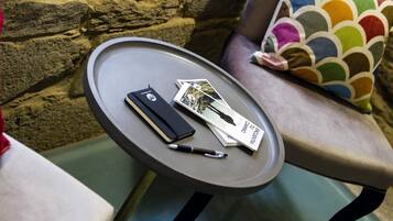A small round table with a notebook, a pen, and a book on it.