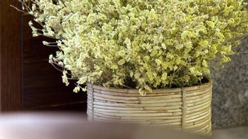 Una planta en maceta con flores blancas sobre una mesa de madera.