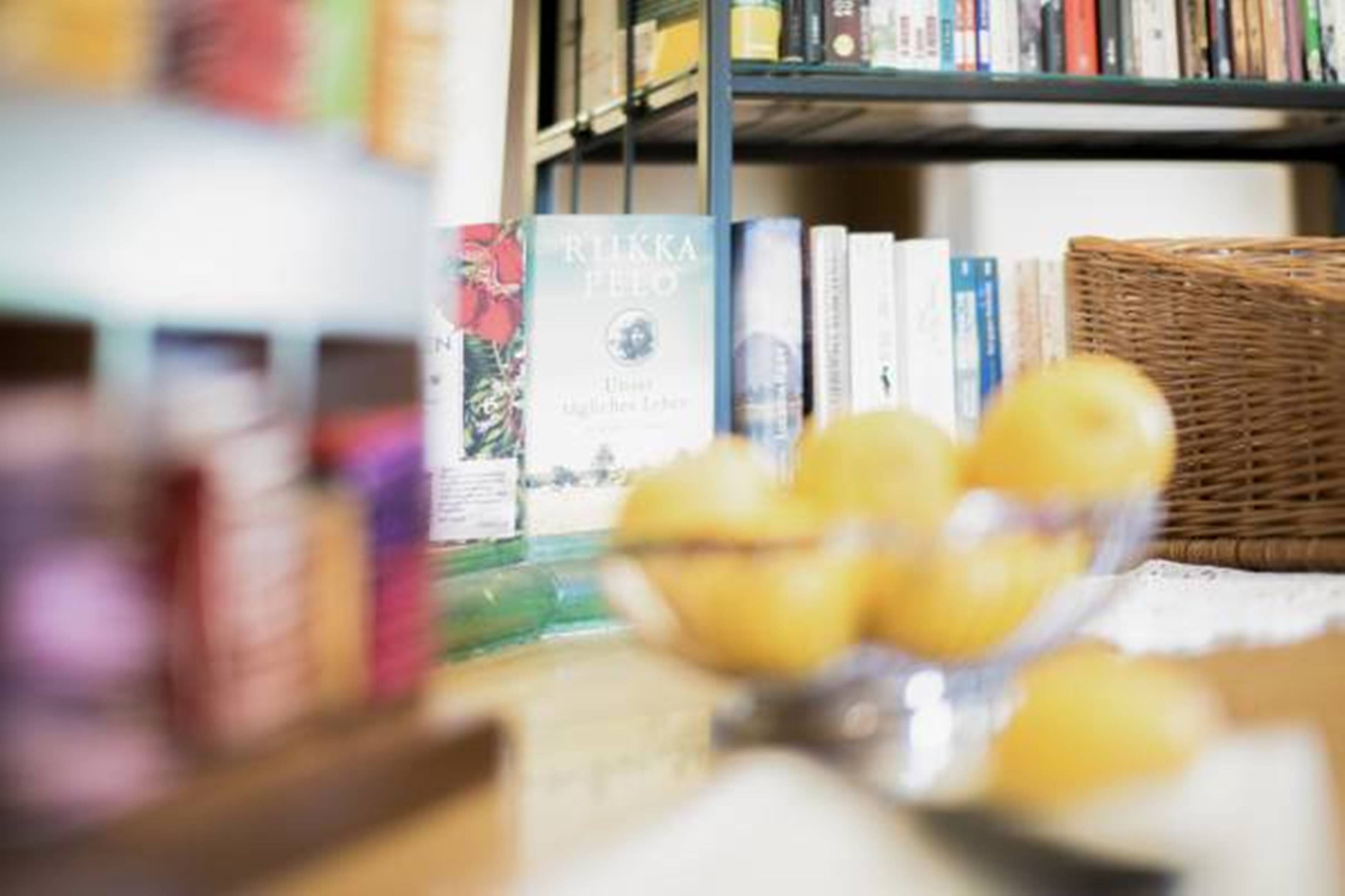 Une bibliothèque remplie de livres et un panier en osier contenant des citrons.