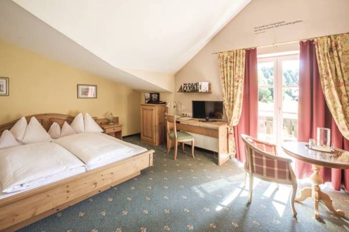 Une chambre à coucher avec un lit, un bureau, une chaise et une table.