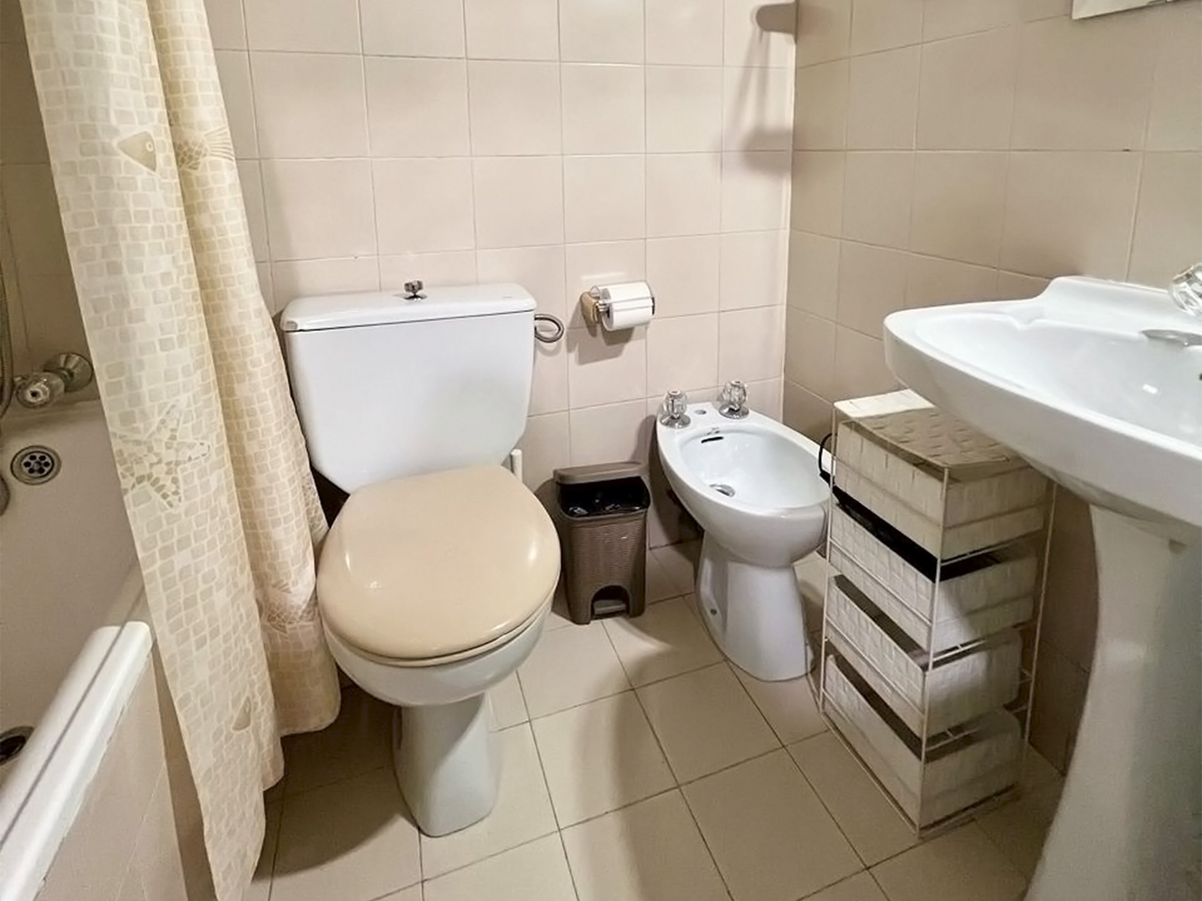 A small bathroom with a toilet, bidet, and sink.