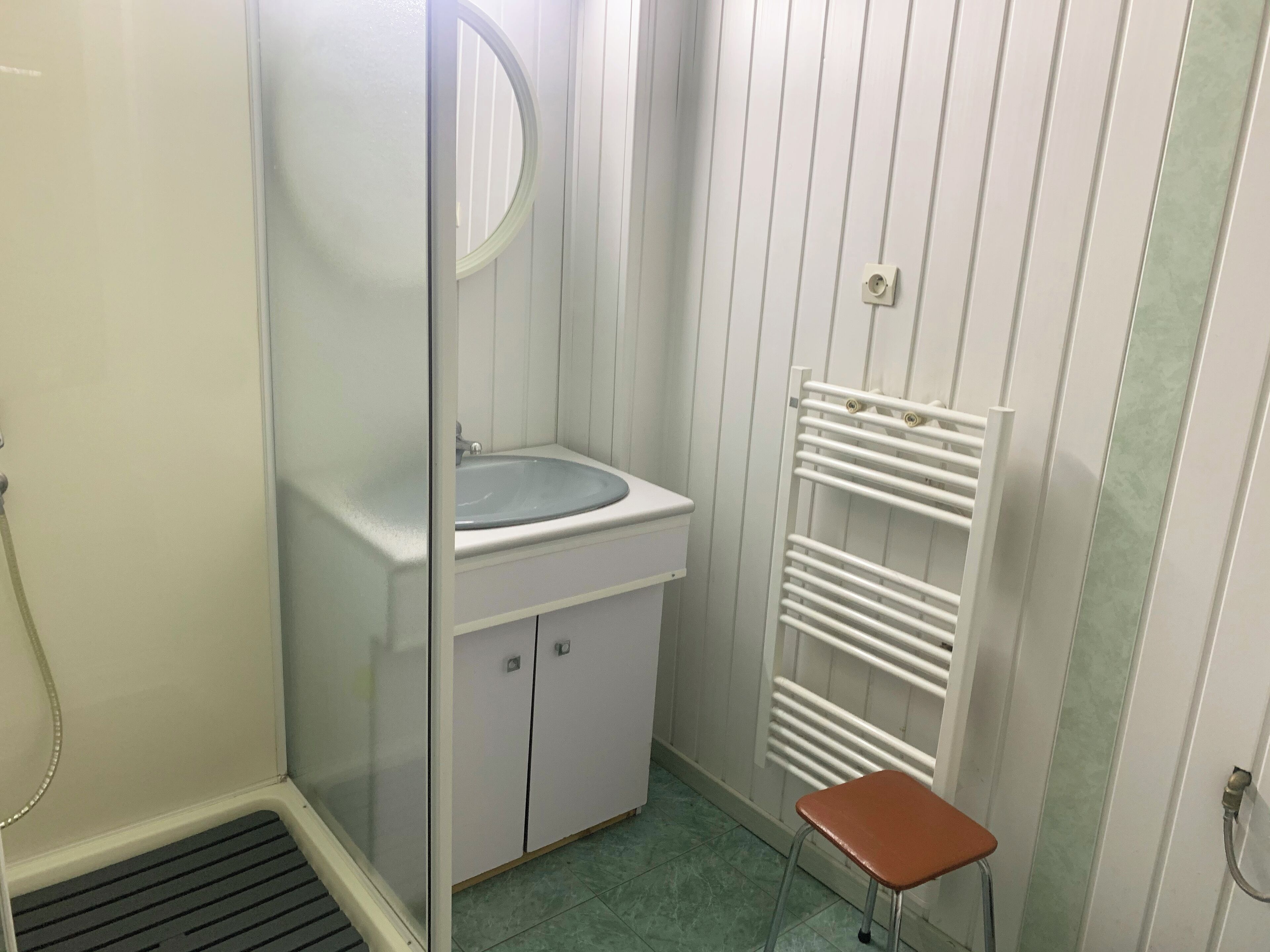 A small bathroom with a sink, mirror, and a towel rack.