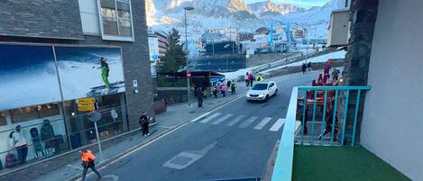 A street view with a building featuring a large window and a mountain backdrop.