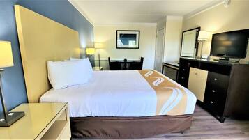 Escritorio, cortinas blackout y tabla de planchar con plancha