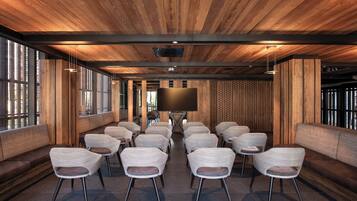 A conference room with a wooden ceiling, large windows, and a flat-screen TV.