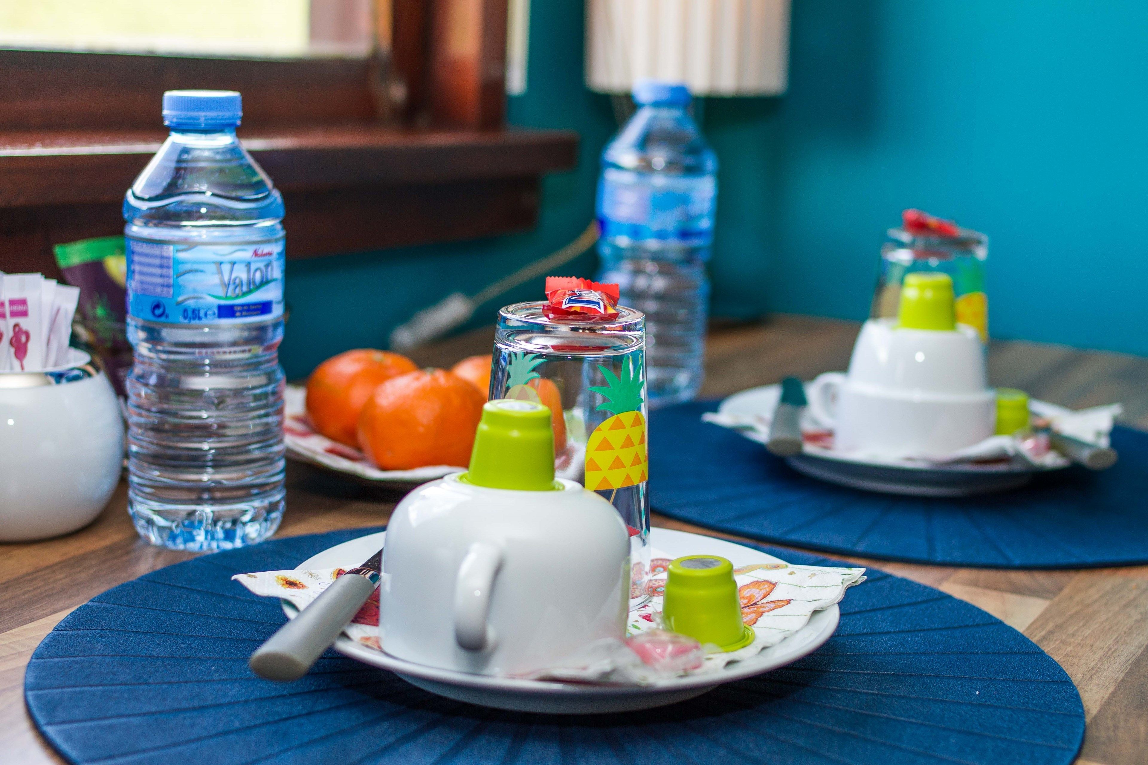 Een eettafel met borden, bestek en waterflessen.