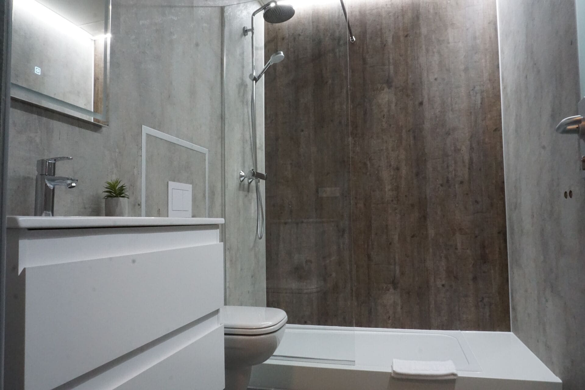 Un baño moderno con ducha, inodoro y lavabo.