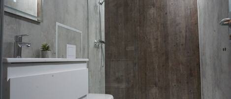 Un baño moderno con ducha, inodoro y lavabo.