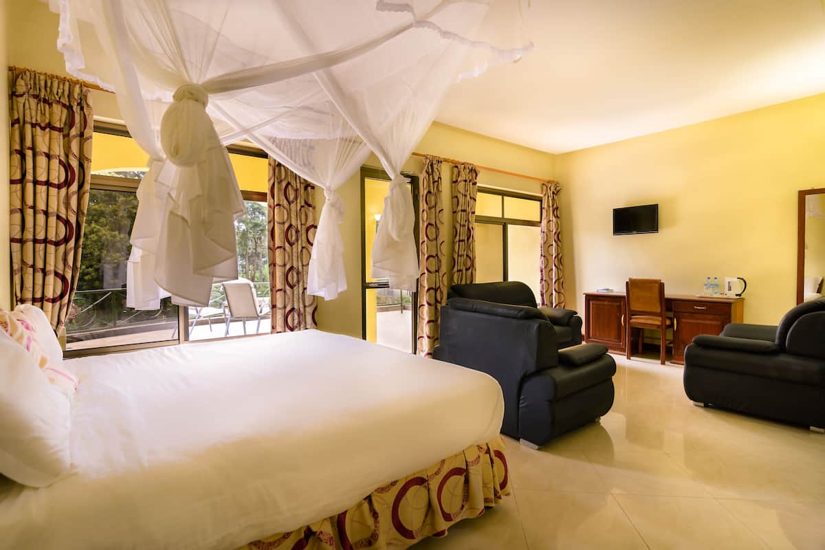 A hotel room with a bed, a massage chair, a desk, and a TV.