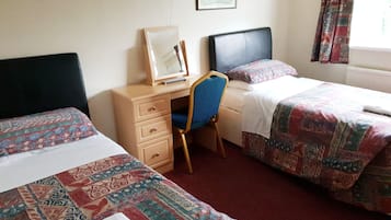 Habitación de hotel con dos camas, un escritorio y una silla.