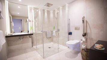 A modern bathroom with a glass-enclosed shower, a toilet, and a sink.