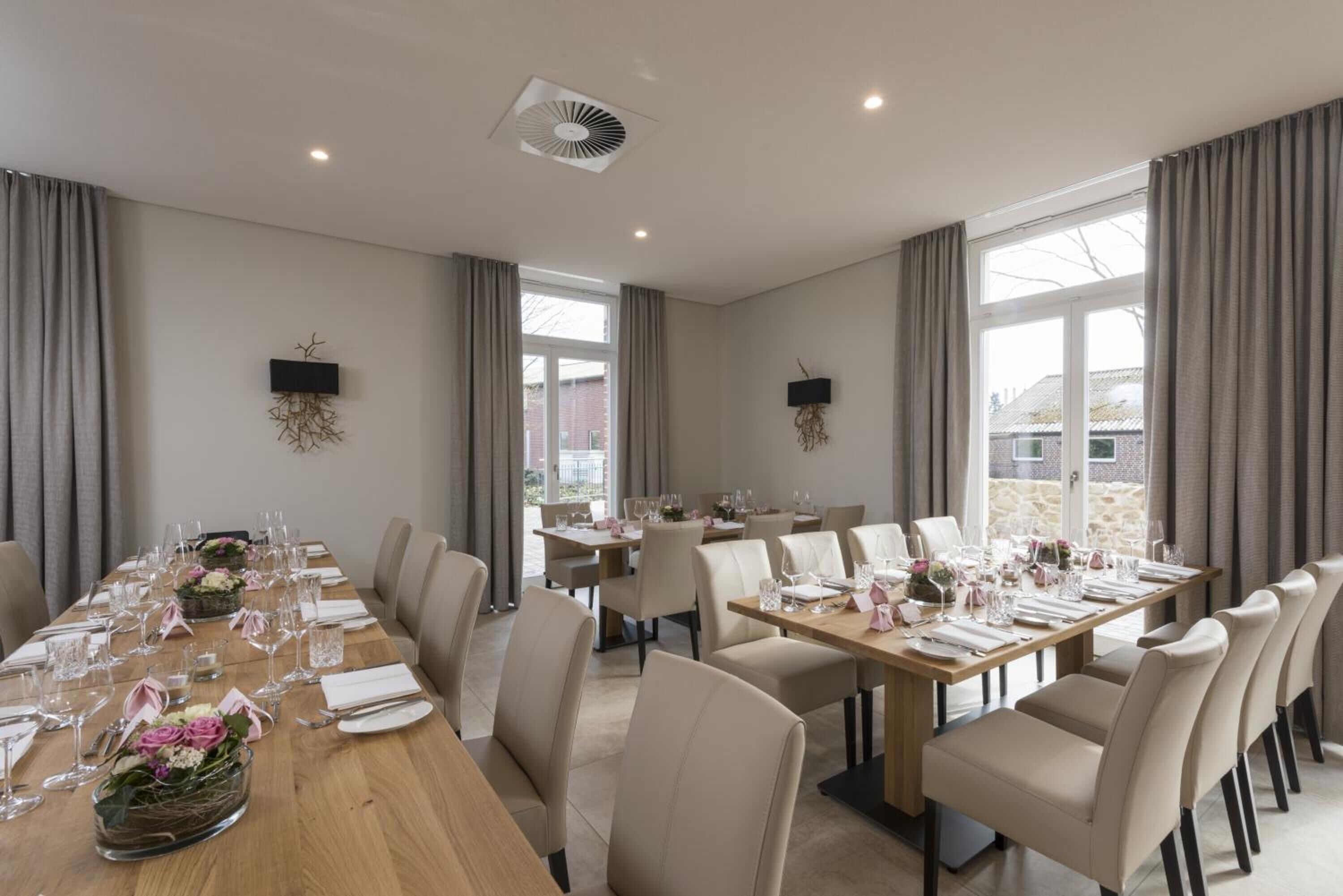 A conference room with multiple tables set for dining, equipped with chairs and glassware.