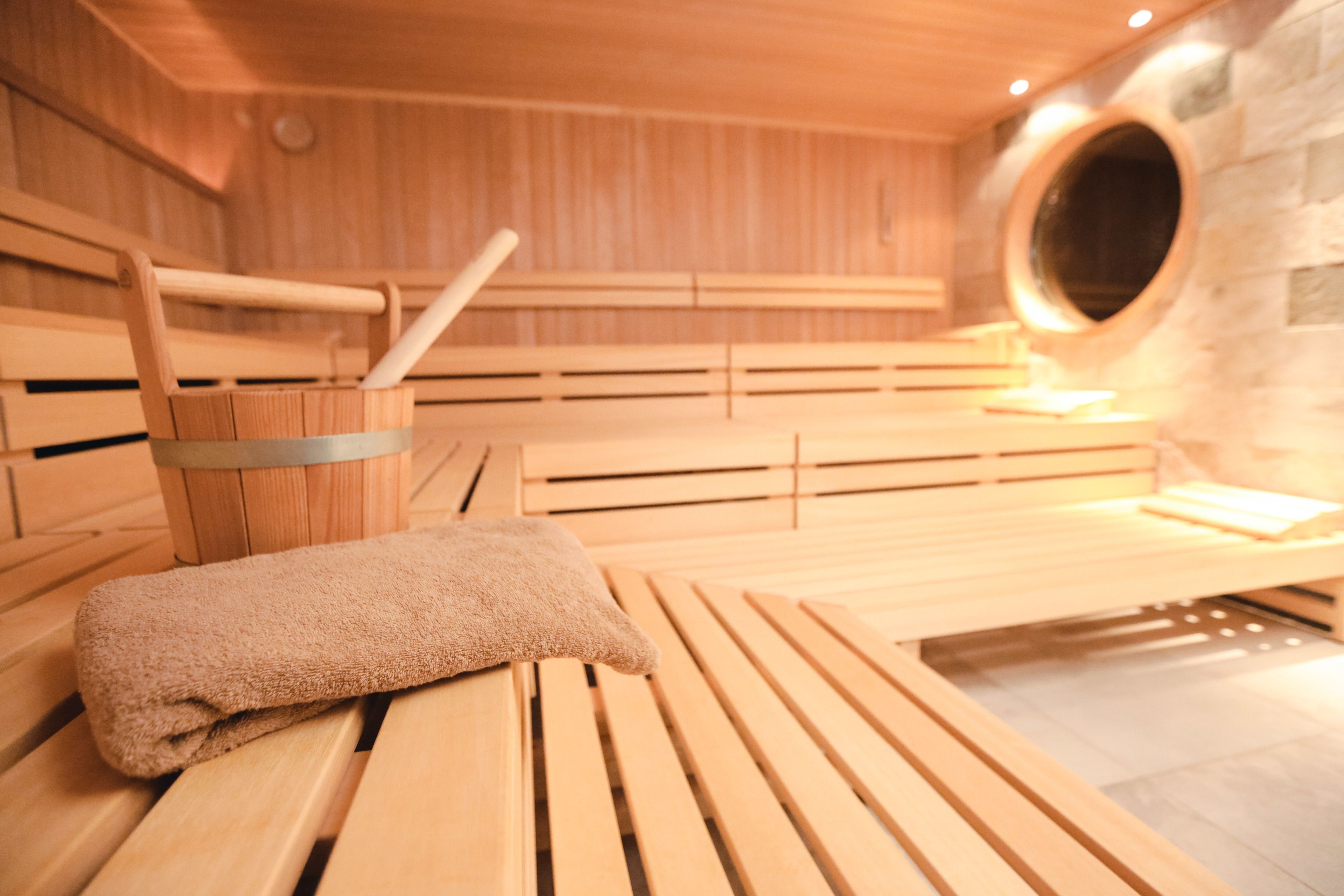 Una sauna con bancos de madera y una toalla sobre uno de ellos.