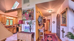 Un interior acogedor con pisos de madera, un banco rústico, un colcha colorida y un farol tradicional.