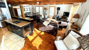 A spacious living area with a wooden floor, a kitchen with granite countertops, a dining area, and a fireplace.