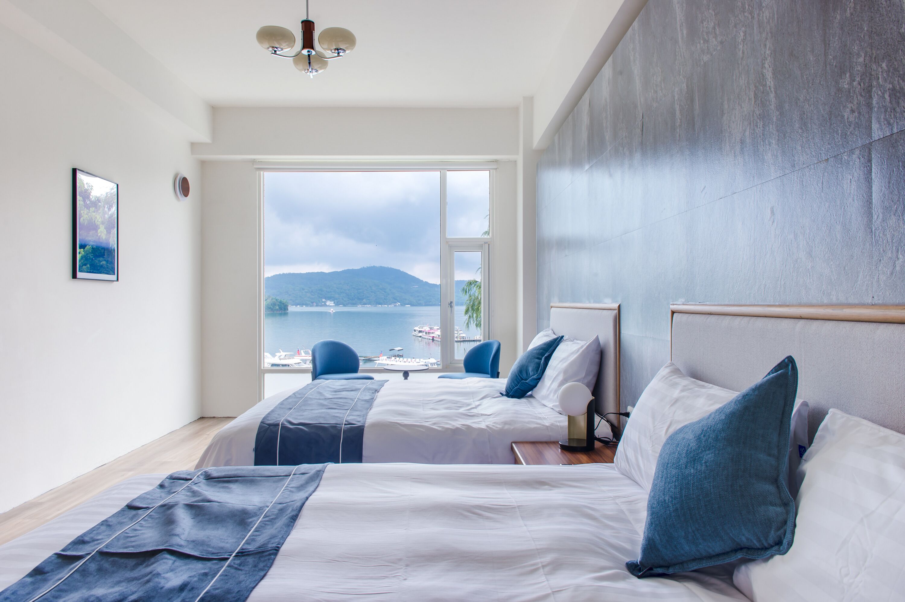 Een hotelkamer met twee bedden, uitzicht op zee en een modern design.
