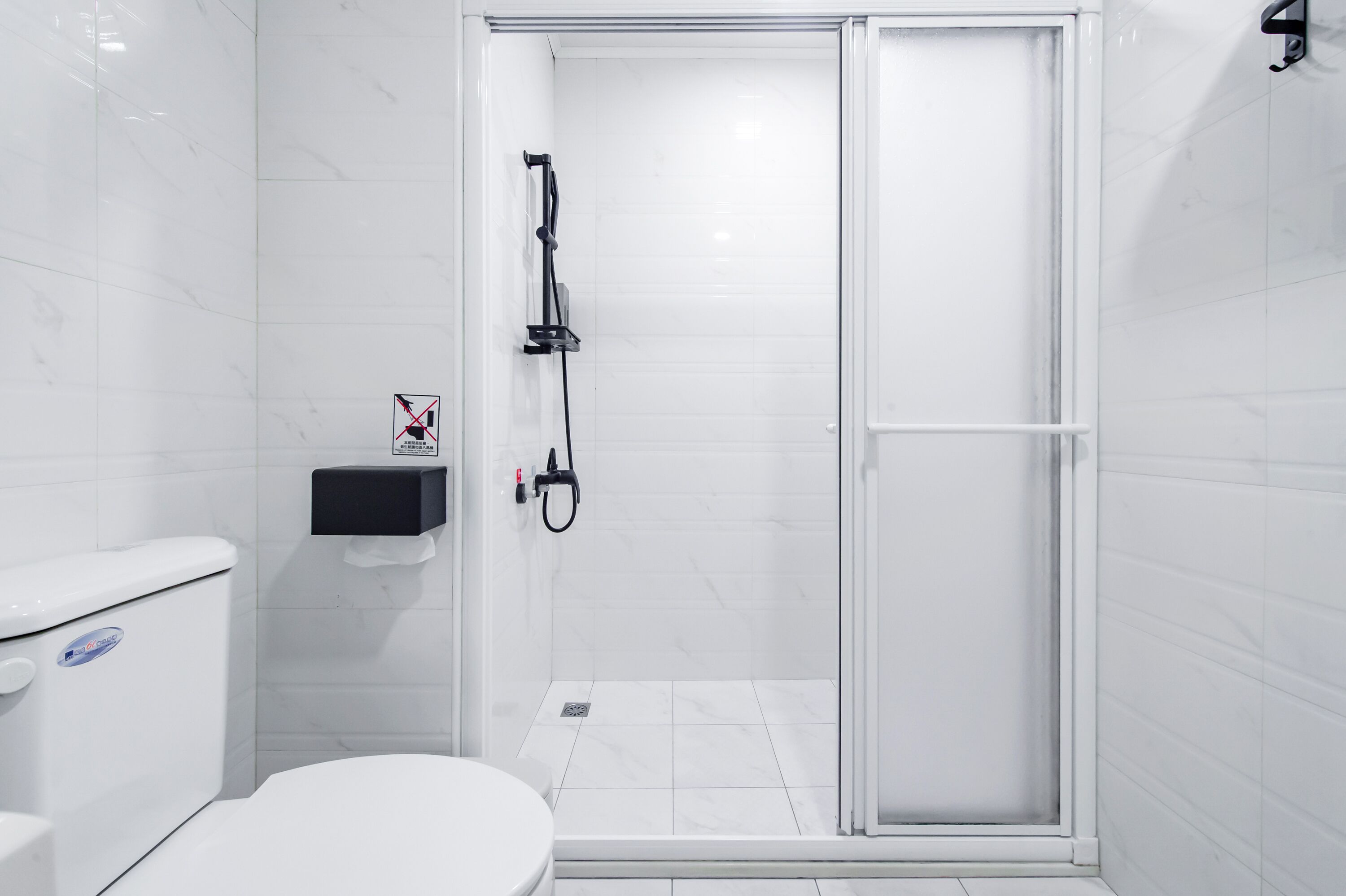 Un bagno con il water, un lavandino e una cabina doccia in vetro.