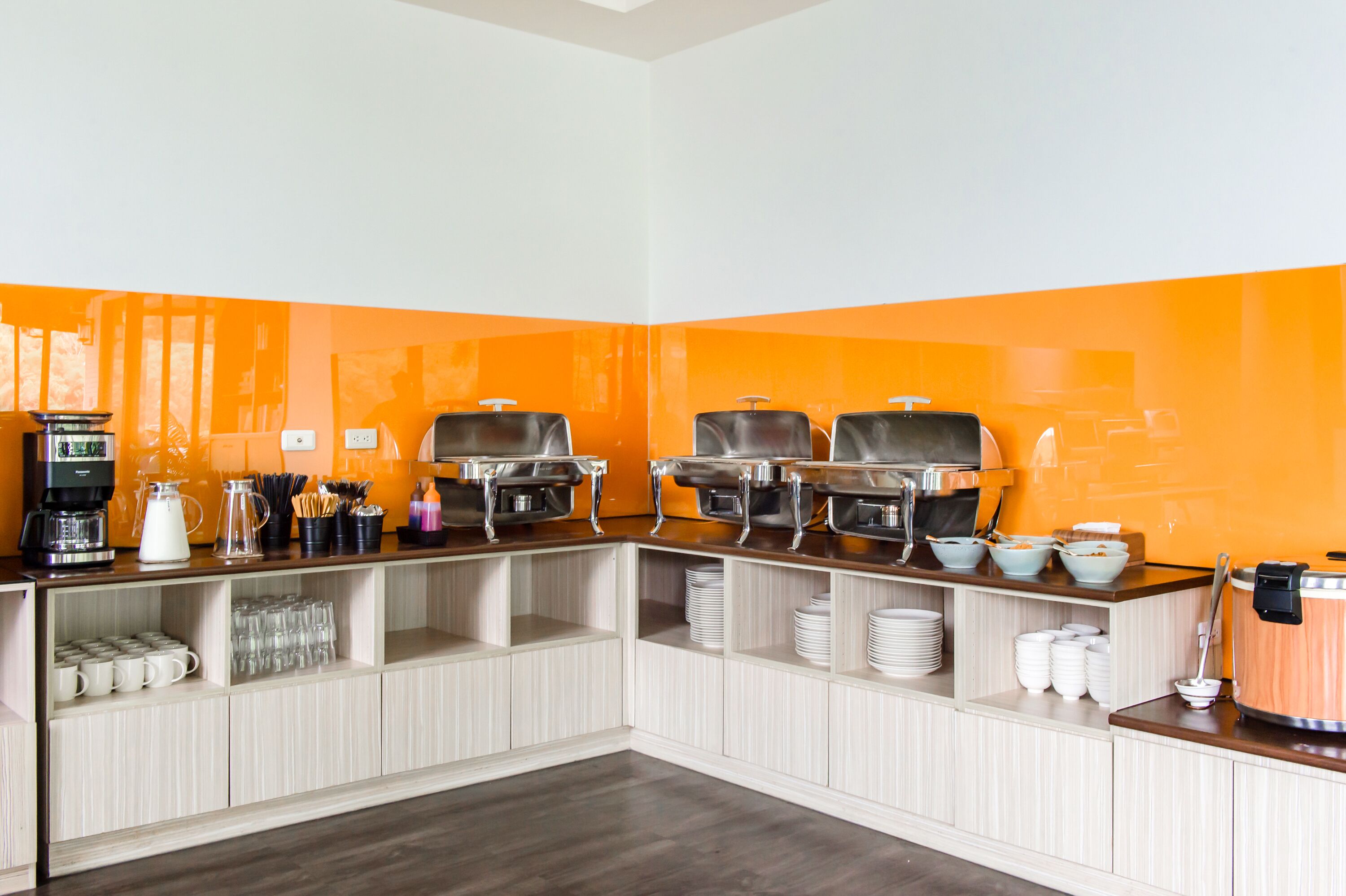 A buffet setup with multiple serving stations, a coffee machine, and various dishes and utensils.
