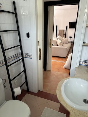 A bathroom with a white sink, a toilet, and a towel rack.