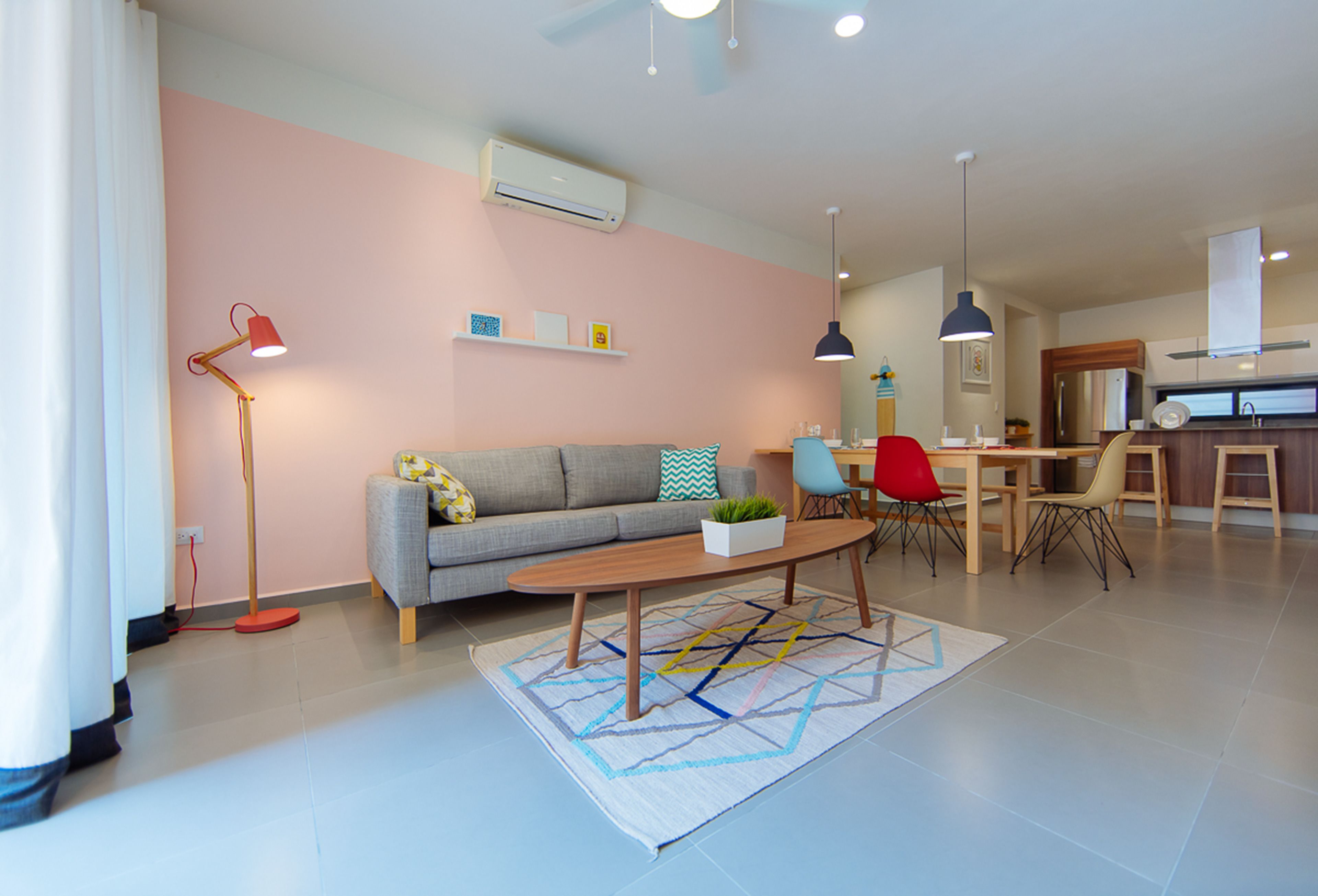 A modern living room with a sofa, coffee table, and dining area.