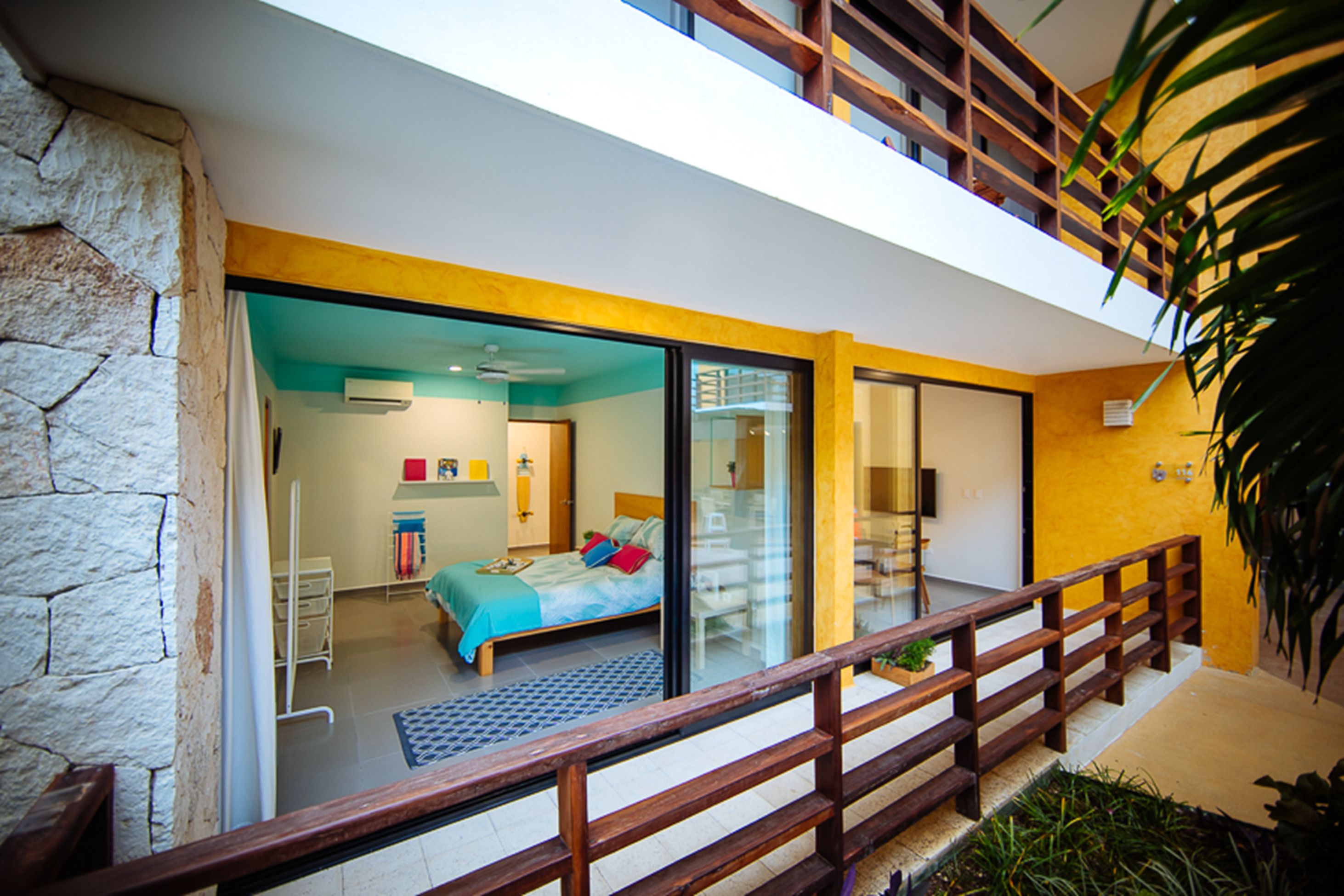 A modern bedroom with a bed, a desk, and a large window.