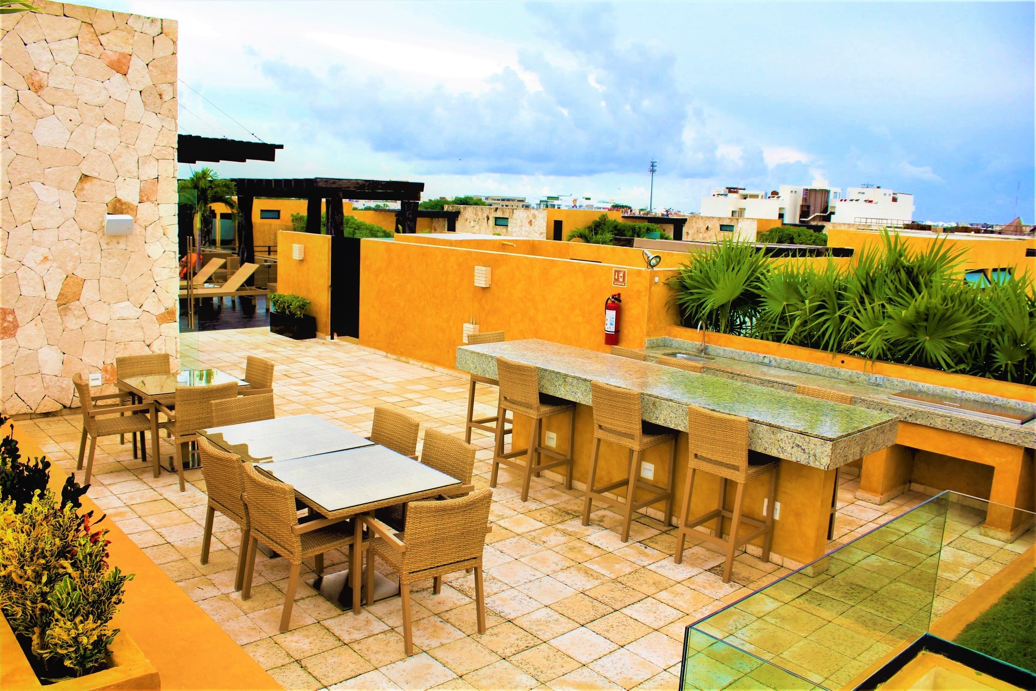 An outdoor patio with a bar area, seating, and a stone wall.