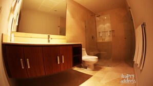 A modern bathroom with a wooden vanity, a large mirror, a toilet, and a glass-enclosed shower area. - Luxurious 2BR Condo surrounded by nature by Happy Address (Playa del Carmen)