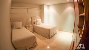 A bedroom with two beds, a nightstand, and a wardrobe. - Fabulous 3BR Condo steps away from 5th Avenue and beach by Happy Adddress (Playa del Carmen)