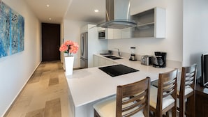 Una cocina moderna con una isla central, electrodomésticos de acero inoxidable y una zona de comedor con sillas de madera.
