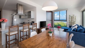 Una cocina moderna con comedor, televisor y un amplio ventanal con vistas.
