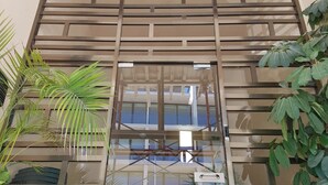 Fachada de edificio moderno con un amplio ventanal y estructura de celosía metálica.