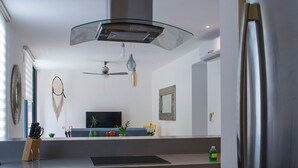 Una cocina moderna con electrodomésticos de acero inoxidable, una campana extractora de vidrio y un horno empotrado.