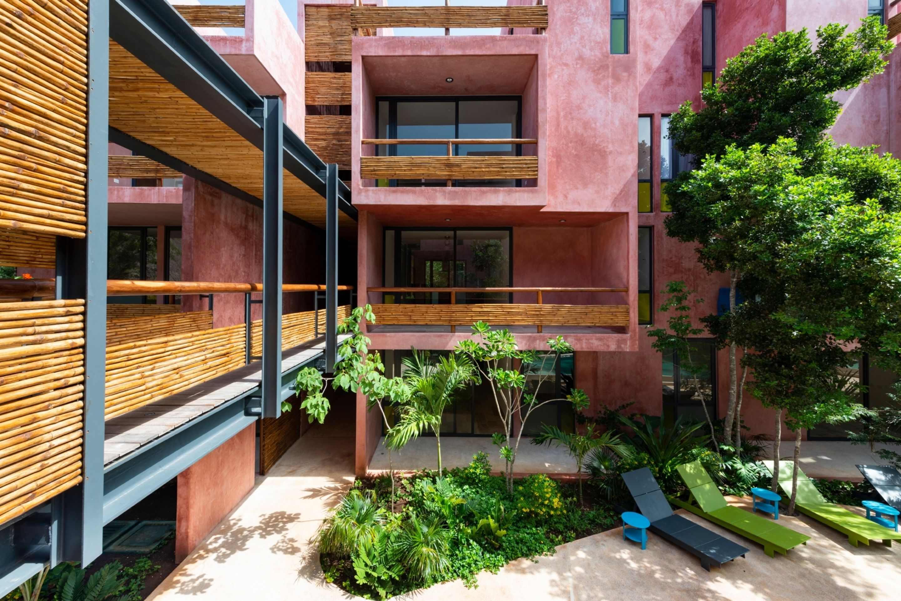 A modern building with a courtyard featuring outdoor seating and greenery.