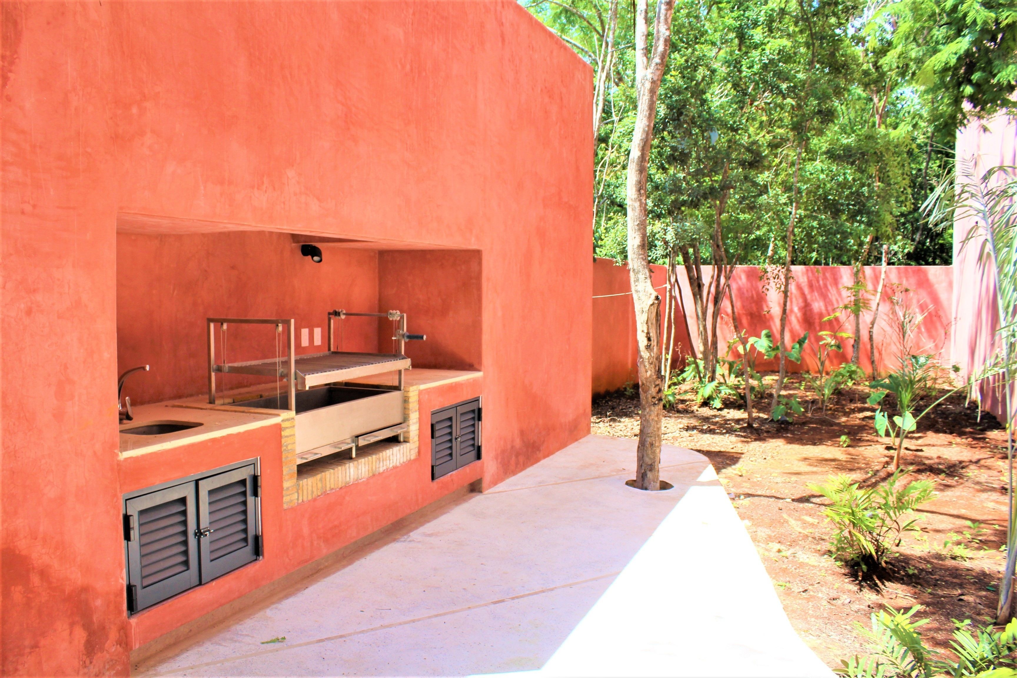 Un edificio rojo con una zona de cocina, que incluye un lavamanos y una encimera.