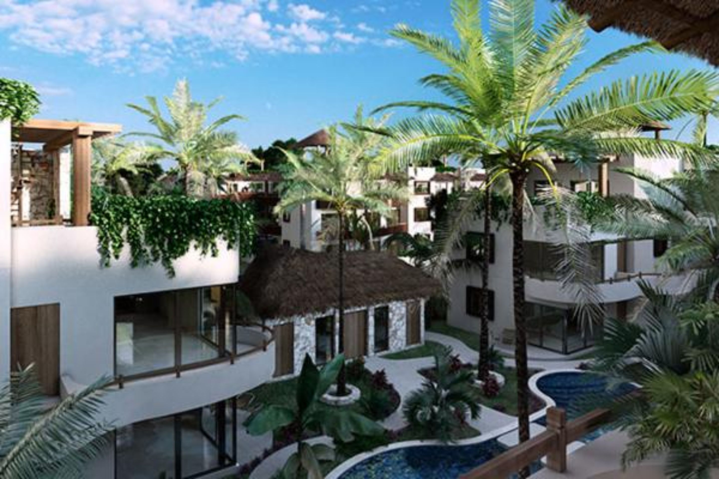Un complejo turístico con varias edificaciones, una piscina y abundante vegetación tropical.