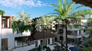 Un complexe hôtelier comprenant plusieurs bâtiments, une piscine et une végétation tropicale luxuriante.