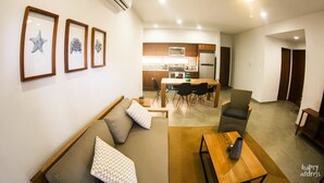 Een moderne woonkamer met een bank, een salontafel en een eethoek met een tafel en stoelen.