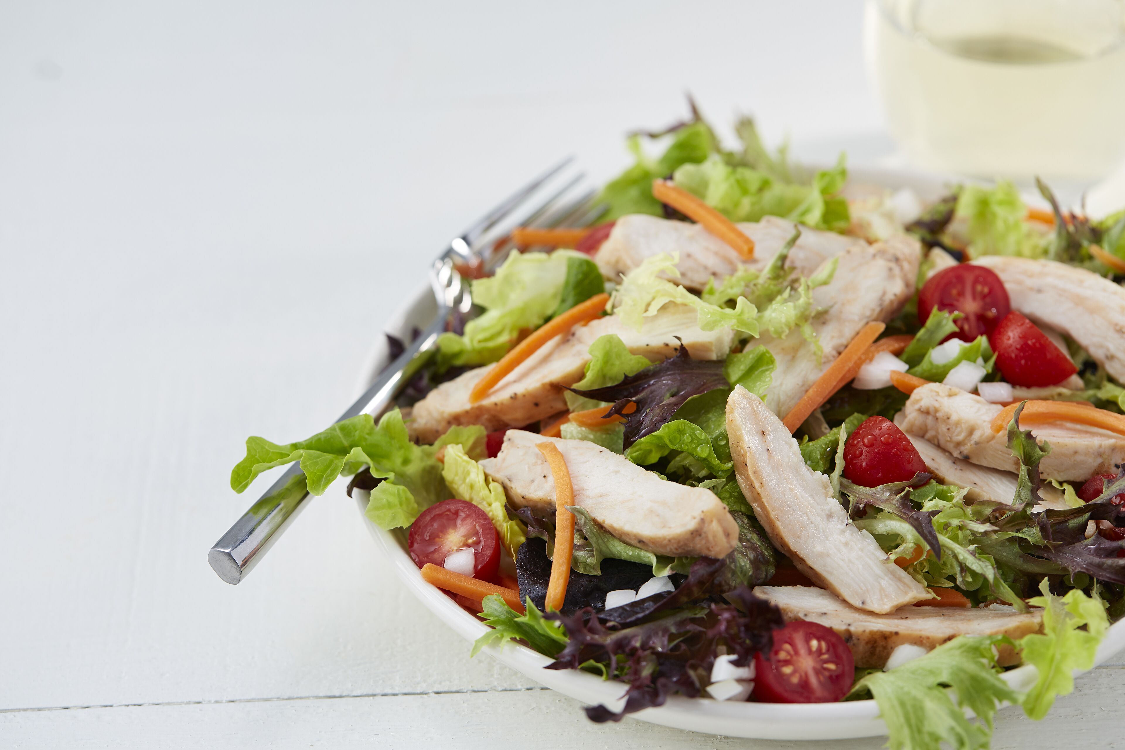 A salad with lettuce, tomatoes, and carrots.