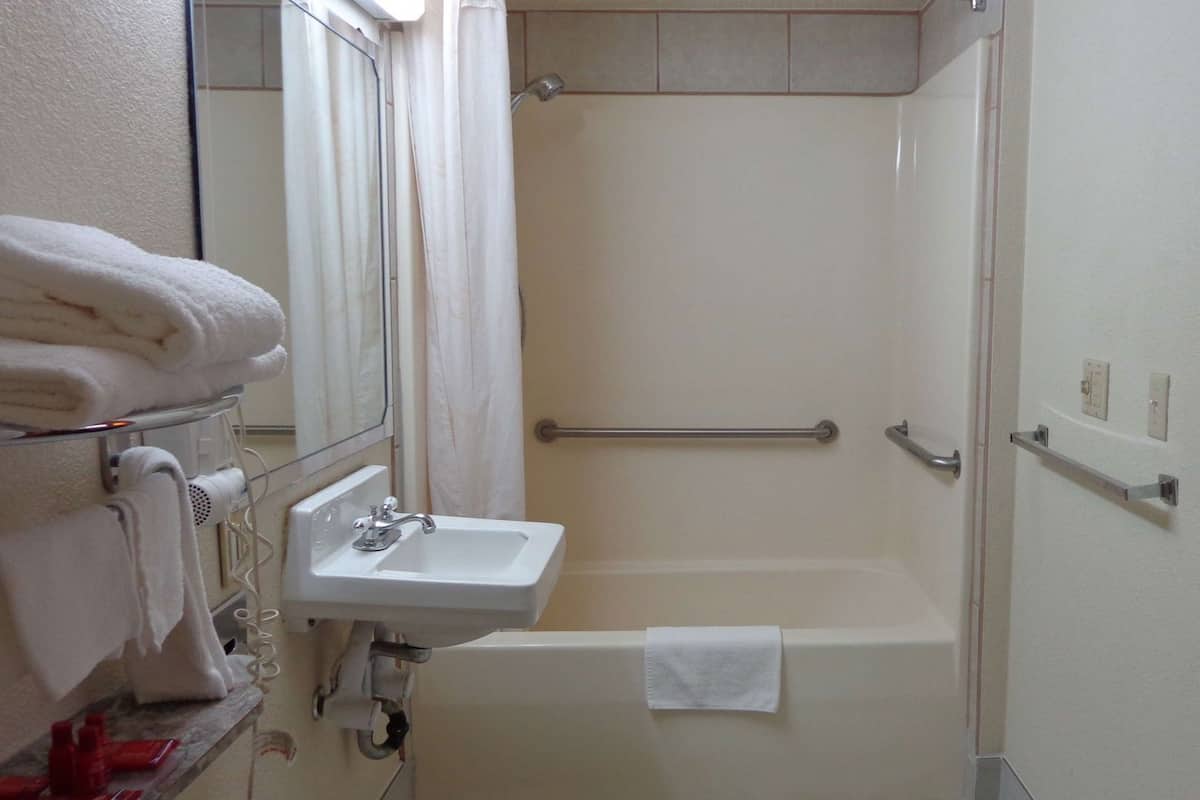 Ein Badezimmer mit Waschbecken, Dusche und Handtuchhalter.