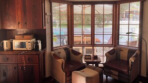 A cozy corner with wooden cabinets, a microwave, and a seating area with two chairs and a small table. - Pelicans Rest Shoalwater Bay
Pelican Retreat (Shoalwater)
