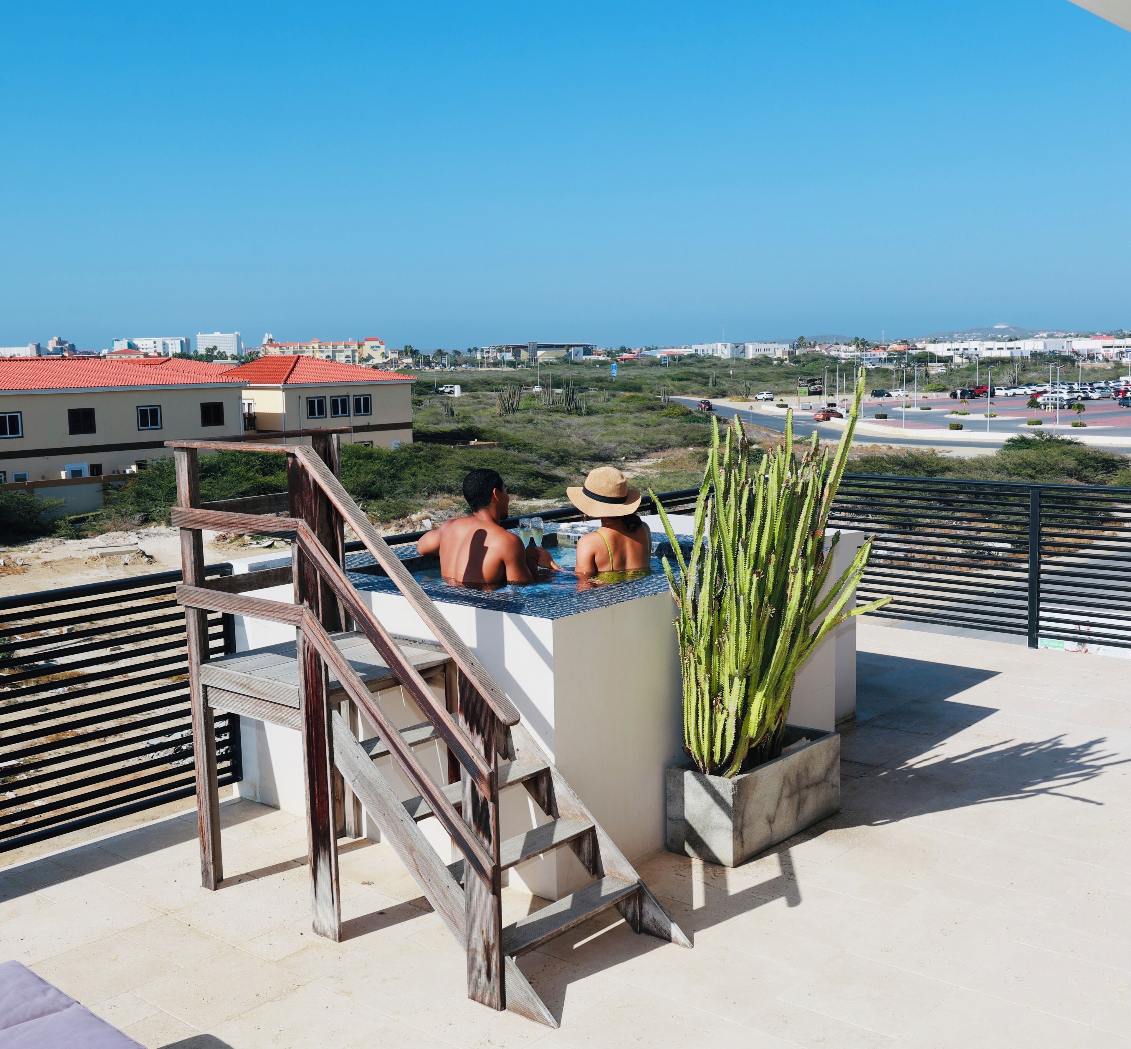 A rooftop pool area with a view of the cityscape and ocean.
