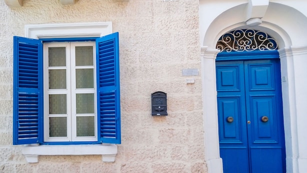 A building facade with a blue window and door, a mailbox, and an arched entrance. - BLU HOUSE  (Sliema)