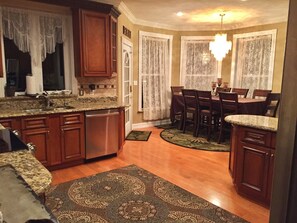 Enjoy meals in the kitchen and dining area, featuring a granite countertop, wooden cabinets, and a dishwasher.