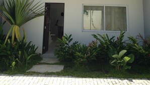 Un edificio de dos pisos con un balcón, una puerta y una ventana.