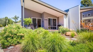 A modern house with a covered patio, surrounded by lush greenery and a well-maintained garden. - 2bdr villa in Dunsborough (Dunsborough)