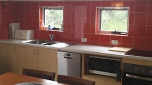 A kitchen with two windows, a dishwasher, an oven, and a sink. - 2bdr villa in Dunsborough (Dunsborough)