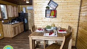 A wooden cabin interior with a kitchen and dining area.